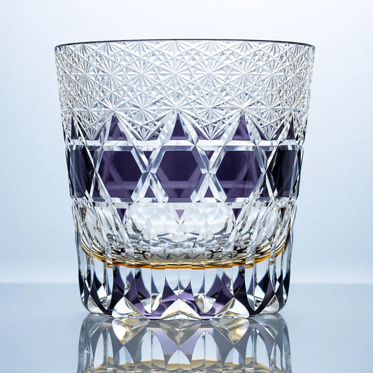 An amethyst hand-cut Edo Kiriko whiskey glass featuring dense crystal starburst cuts, a violet geometric band, and a polished reflective studio presentation.