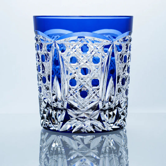 A blue hand-cut Edo Kiriko whiskey glass featuring cobalt blue circular motifs, clear faceted crystal cuts, a deep blue rim, and a polished reflective studio presentation.