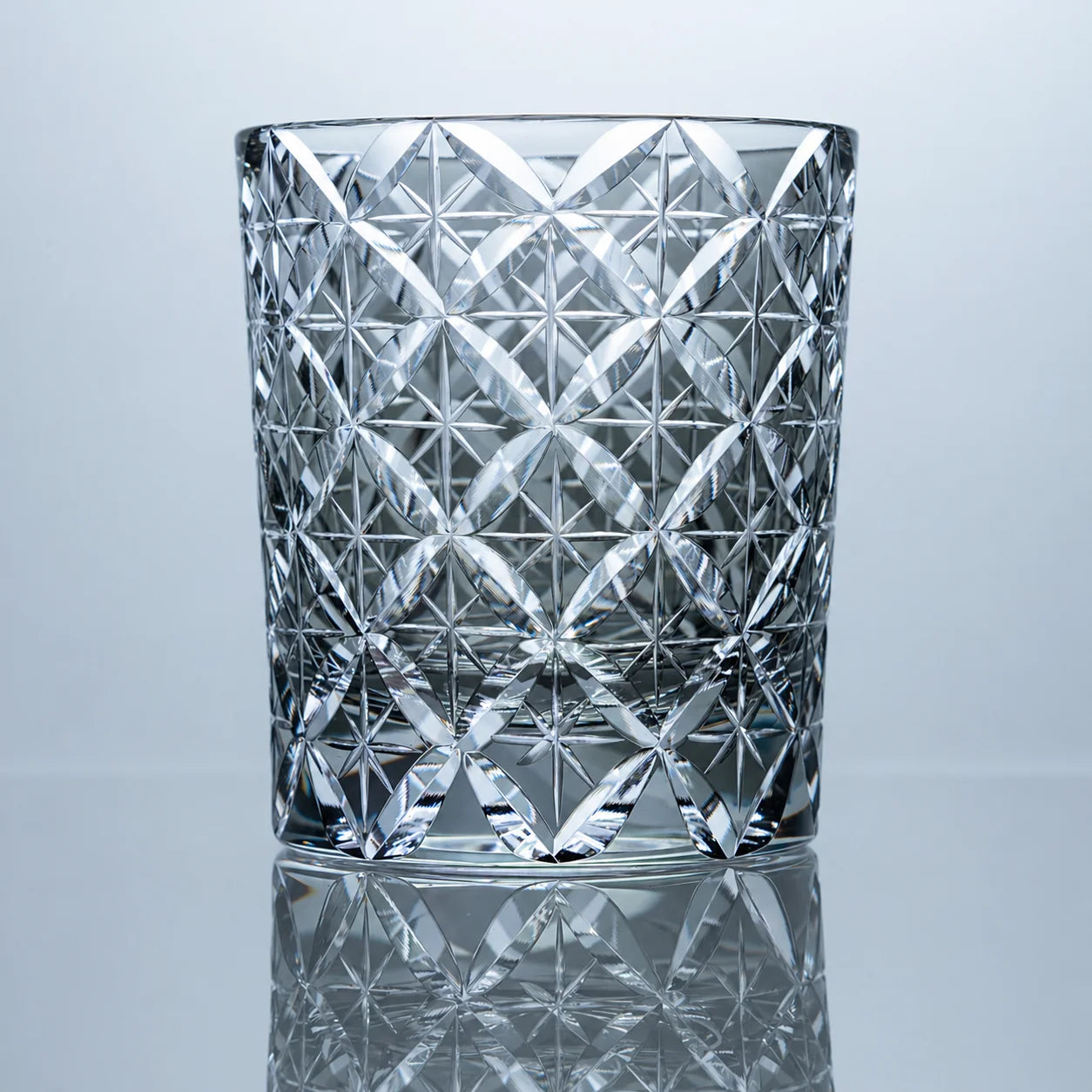 A smoke gray hand-cut Edo Kiriko whiskey glass featuring an allover Shippo-inspired crystal lattice pattern, clear-gray tones, and a polished reflective studio presentation.