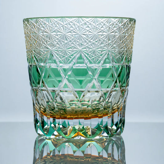 A green hand-cut Edo Kiriko whiskey glass featuring dense crystal starburst cuts, a luminous green geometric band, clear faceted detailing, and a polished reflective studio presentation.