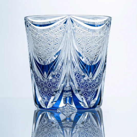 A back view of the Sapphire Veil Edo Kiriko whiskey glass showing curved crystal cuts, blue accents, geometric lattice patterns, and polished clear detailing.